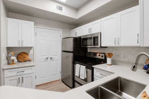 Kitchen with stainless steel appliances and white cabinets at Townhomes of Bent Tree