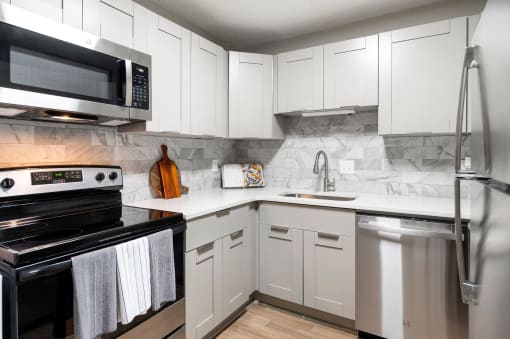 Kitchen with grey cabinets and stainless steel appliances