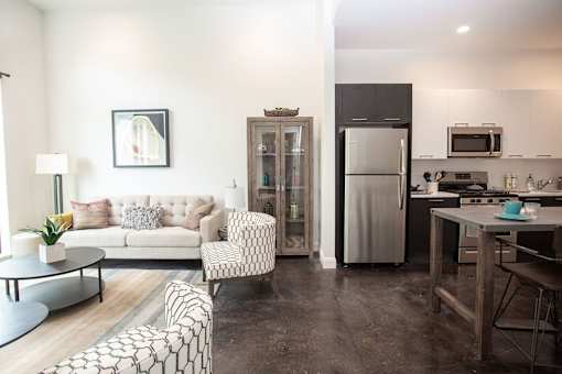 A modern kitchen with a refrigerator, microwave, and oven.