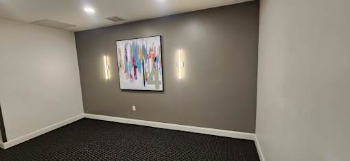 Empty room with abstract art and wall sconces at 68 Beale Apartments, Quincy