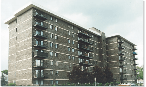 A large concrete building with balconies on each floor.