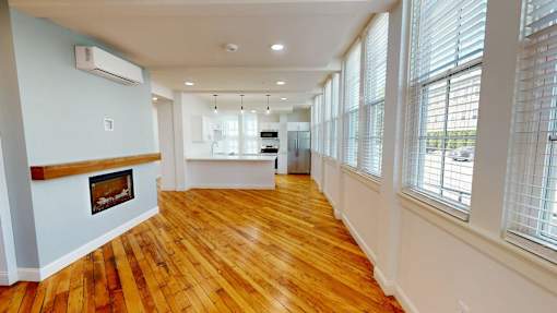 A room with wooden floors and a fireplace.