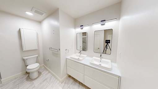 A white bathroom with a toilet, sink, and mirror.