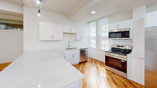 A kitchen with white cabinets and a white counter top.