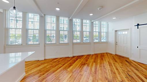 A room with wooden floors and large windows.