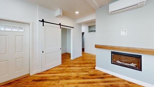 A room with a fireplace and a wooden floor.