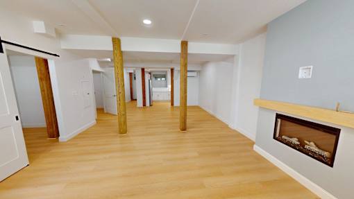 A room with a fireplace and wooden floors.