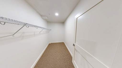 A white hallway with a metal rack on the wall.