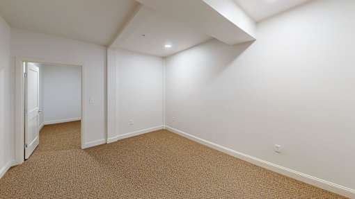 A room with white walls and carpeted floor.