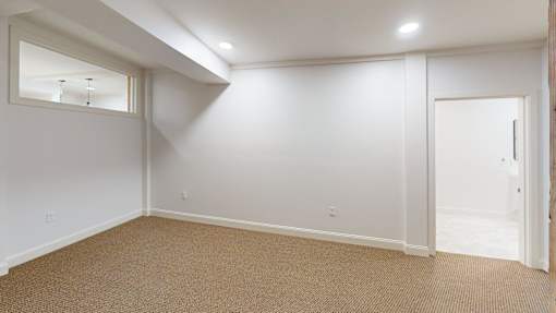 A room with a carpeted floor and a door.