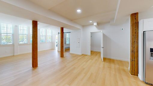A kitchen with a refrigerator on the right side.