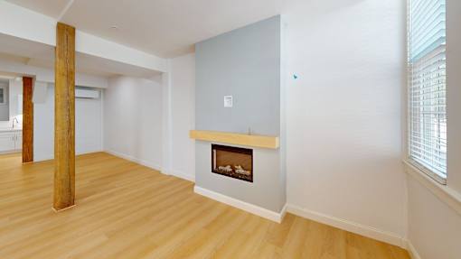 A room with a fireplace and wooden floors.