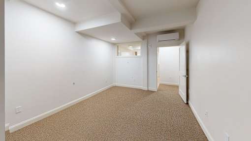 A room with carpeted floor and white walls.