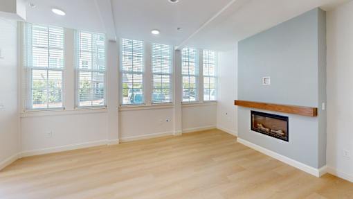 A living room with a fireplace and large windows.