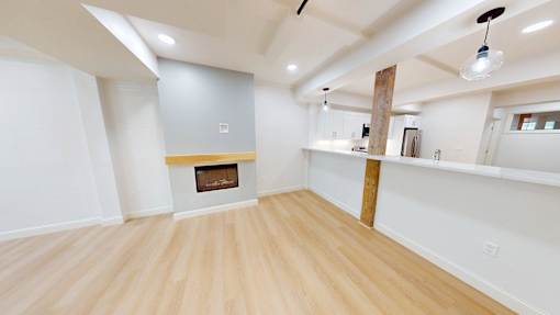 A room with a fireplace and wooden floors.
