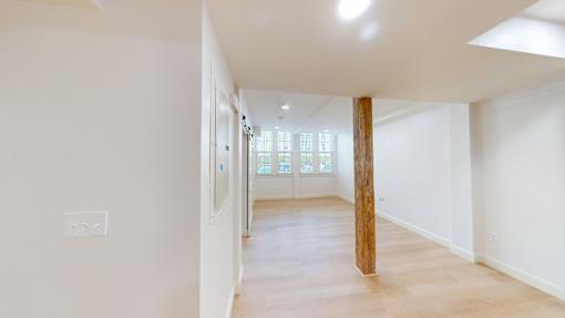 A long hallway with a wooden pillar in the middle.