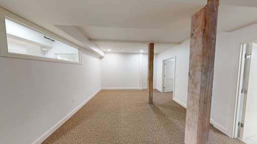 A room with a carpeted floor and white walls.