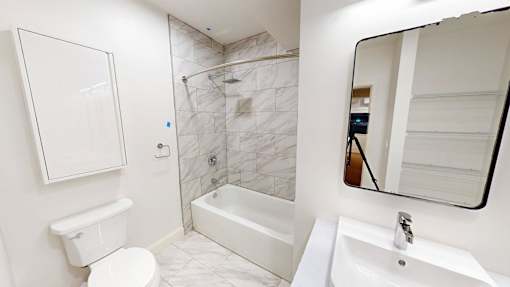 A white toilet sits next to a white sink in a bathroom.