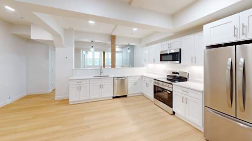 A modern kitchen with white cabinets and stainless steel appliances.
