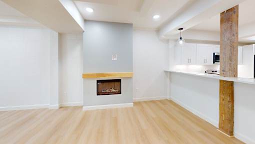 A room with a fireplace and wooden floors.