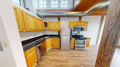 A kitchen with wooden cabinets and a black countertop.