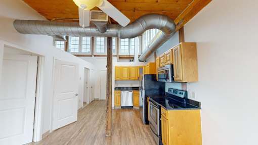 A kitchen with wooden cabinets and a black stove top oven.