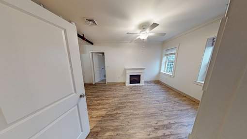 A room with a fireplace and a ceiling fan.