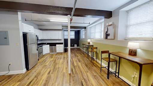 A kitchen with wooden floors and a bar area.