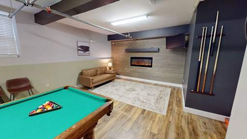 A pool table with a green cloth and a billiard cue.
