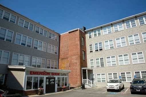 A brick building with a sign that says Emerson Shoe Lofts.