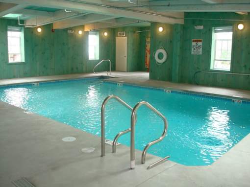A large indoor swimming pool with a ladder on the side.