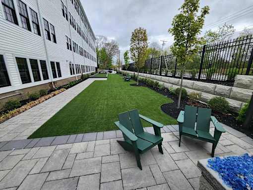 A patio with a bench and a fence.