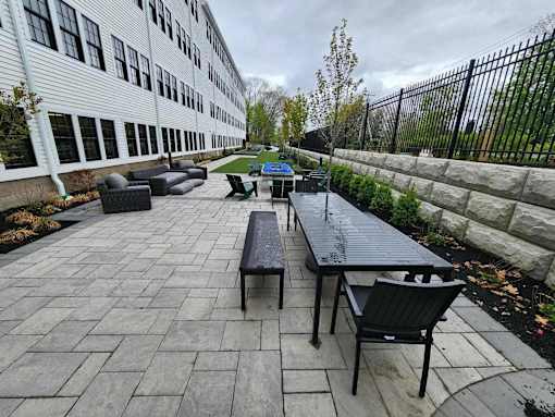 A patio with a table and chairs is in front of a building.