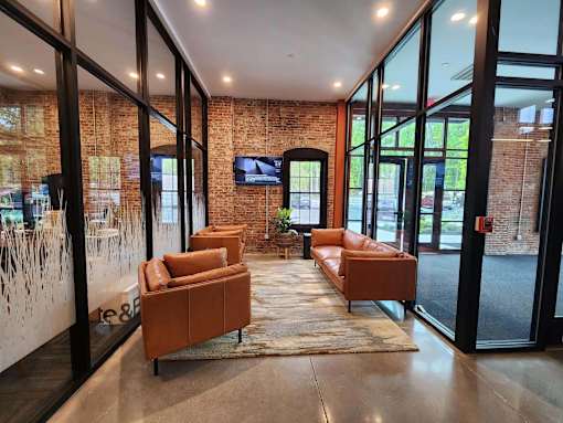 A modern living room with a brick wall and a flat screen TV.