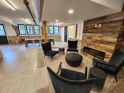 A room with black chairs and a wooden wall.