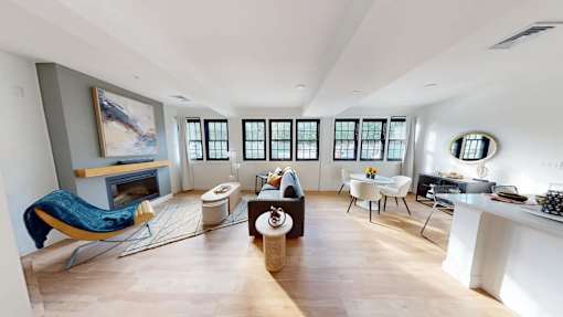 A living room with a fireplace and a painting on the wall.