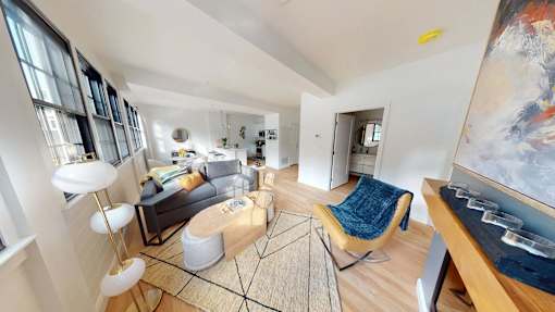 A living room with a large painting on the wall and a rug on the floor.
