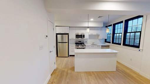A kitchen with white cabinets and a white island.