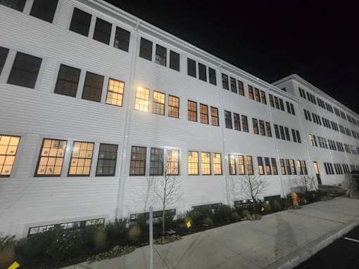 A white building with windows lit up at night.
