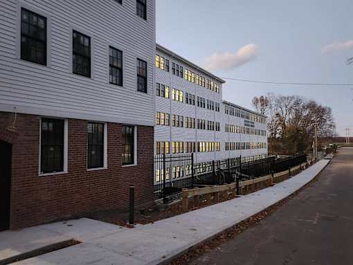 A long white building with a black fence in front of it.