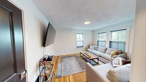 A living room with a grey couch and a wooden coffee table.