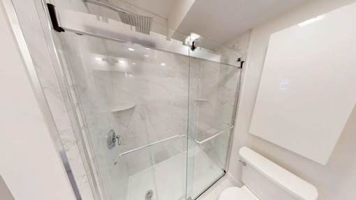 A white bathroom with a glass shower stall.