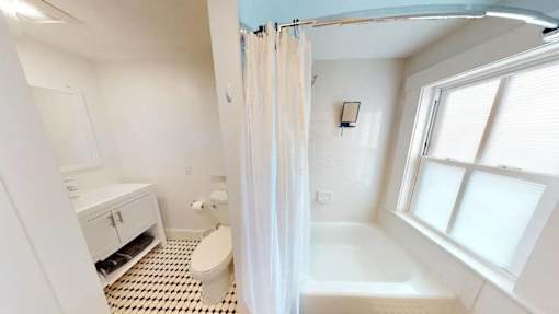A white bathroom with a toilet, sink, and bathtub.