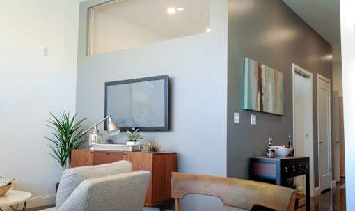 A living room with a grey couch and a wooden table.