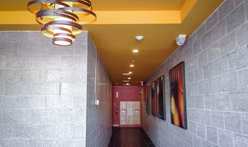A hallway with a yellow ceiling and a red door.