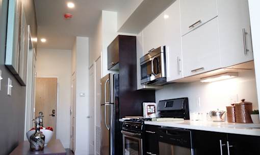 A kitchen with black appliances and white cabinets.