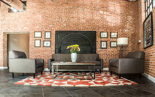 A living room with a brick wall and a fireplace.