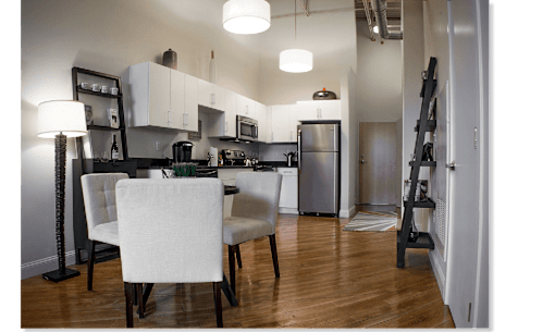 A kitchen with a dining table and chairs.
