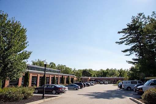 A parking lot with cars and a building in the background.