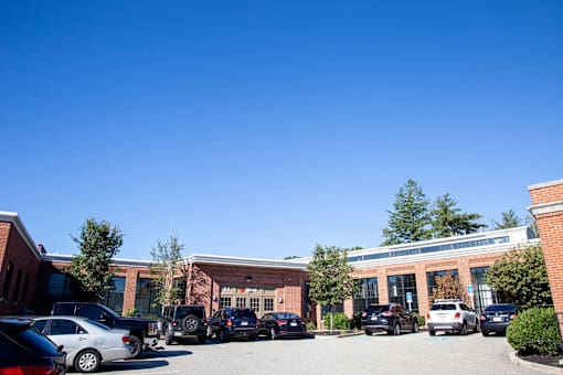 A parking lot with cars and a building in the background.